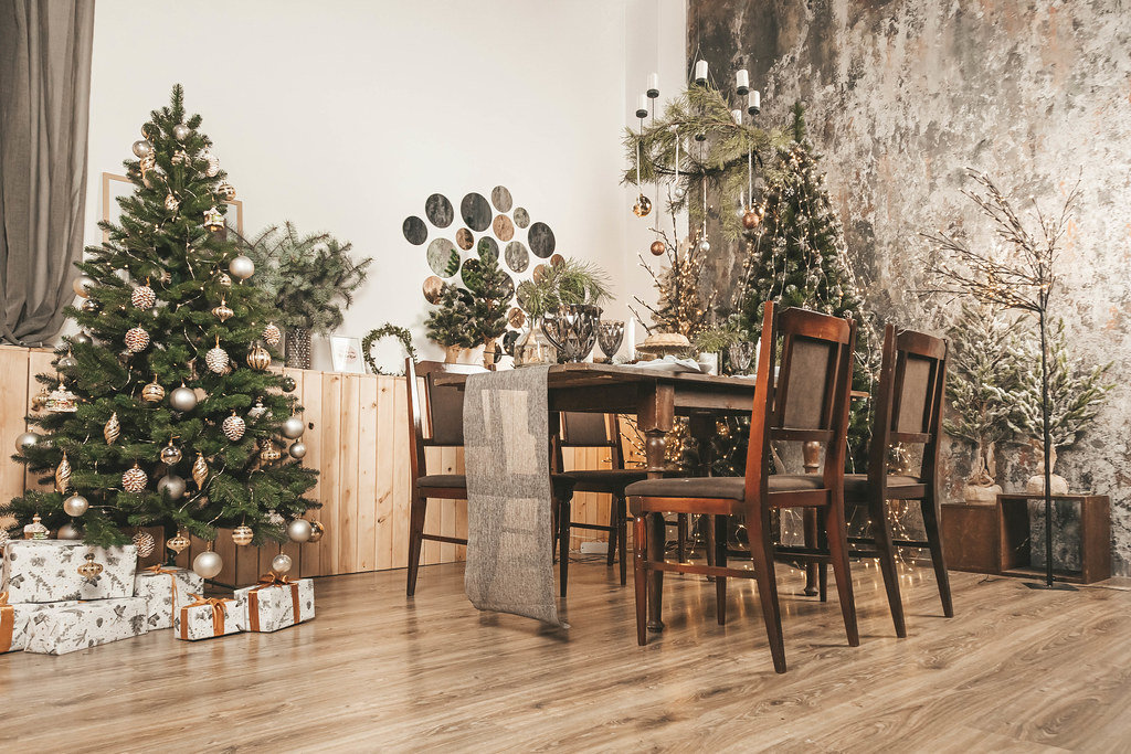 Spacious decorated living room with christmas trees and dining table
