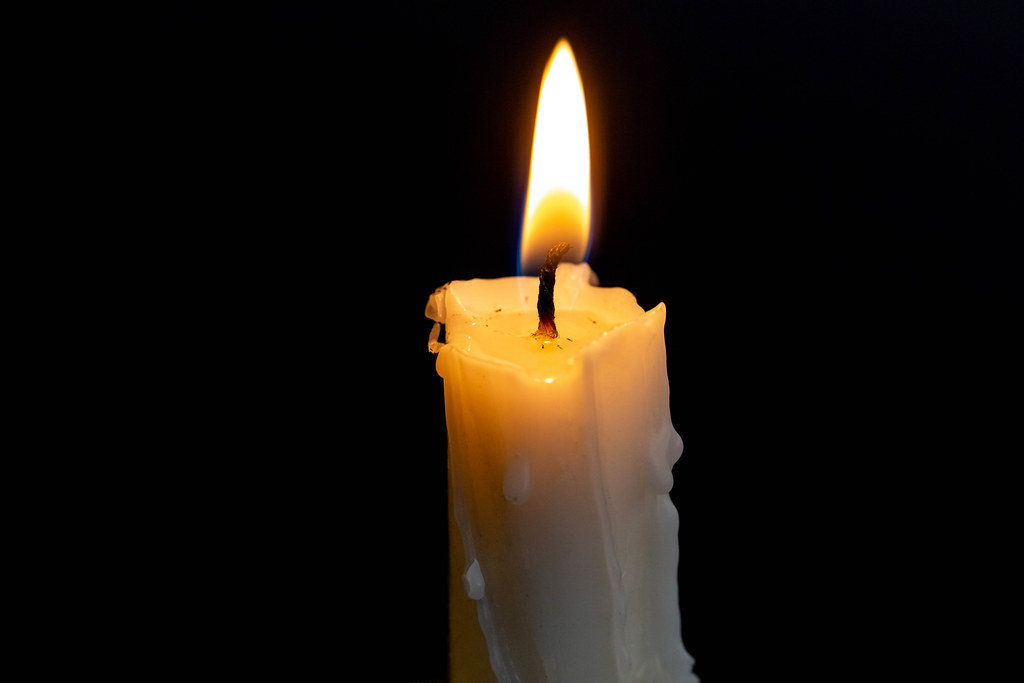 Candle burning brightly in the black background