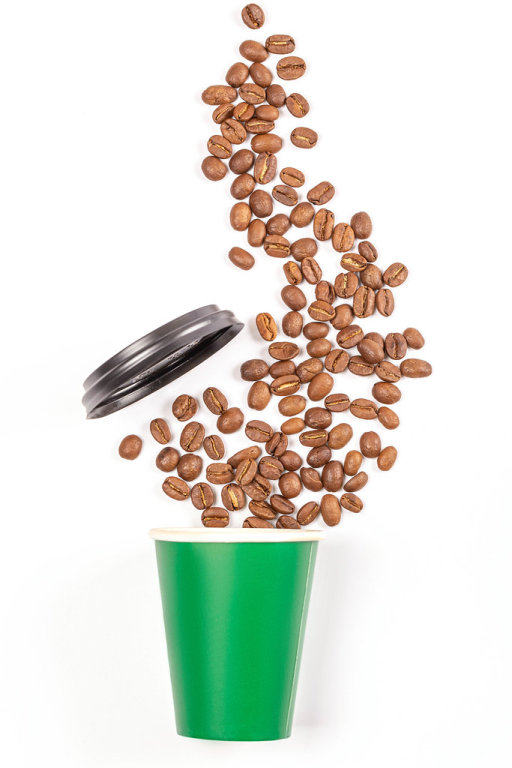 Paper cup with sprinkled coffee beans and lid