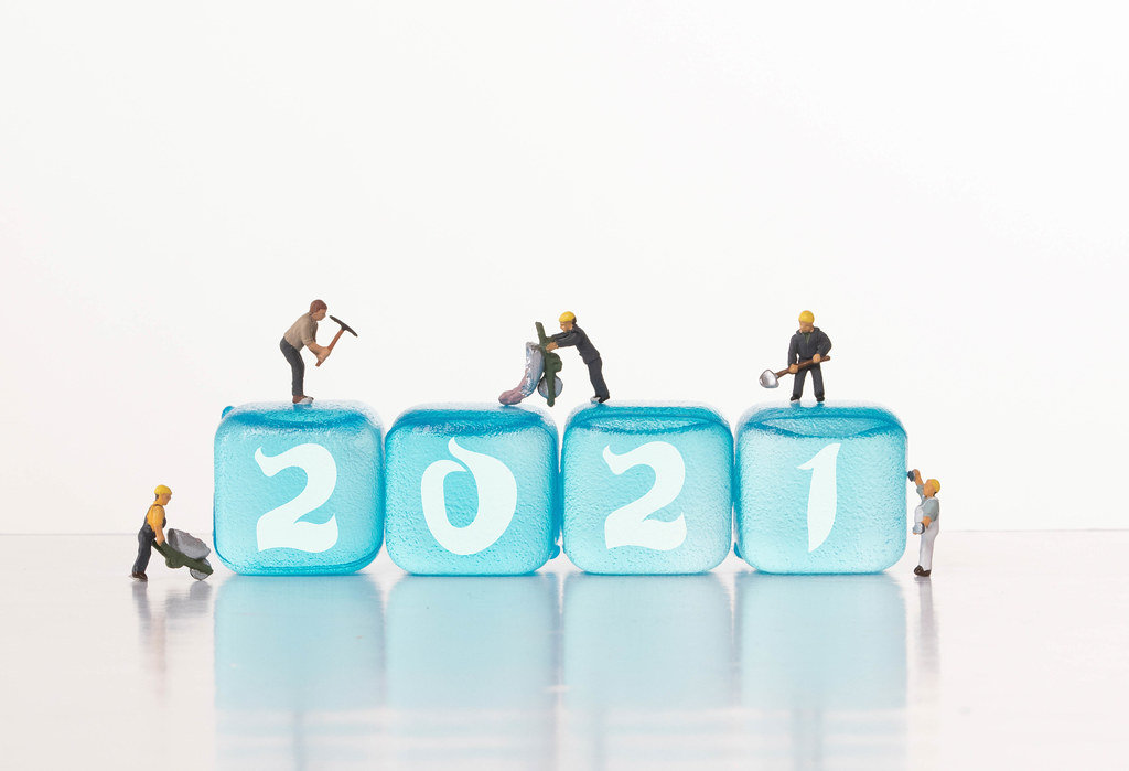 Workers on blue ice cubes with 2021 text
