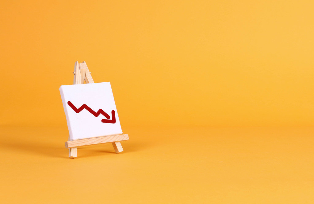 Easel with a red down arrow on orange background