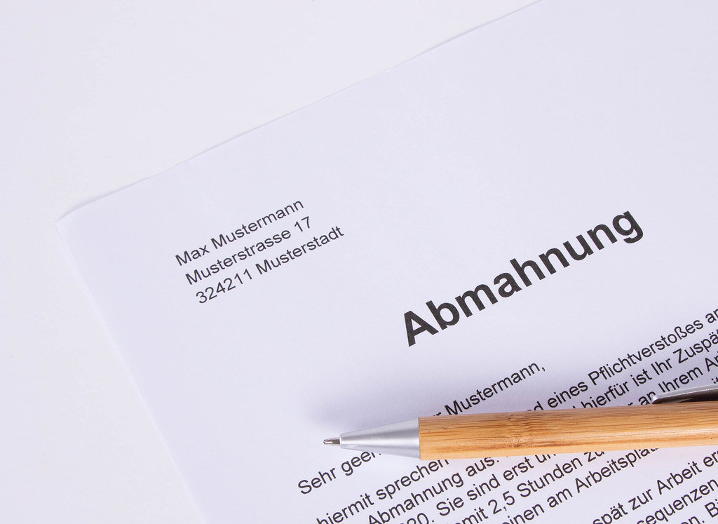Abmahnung document with pen on white table