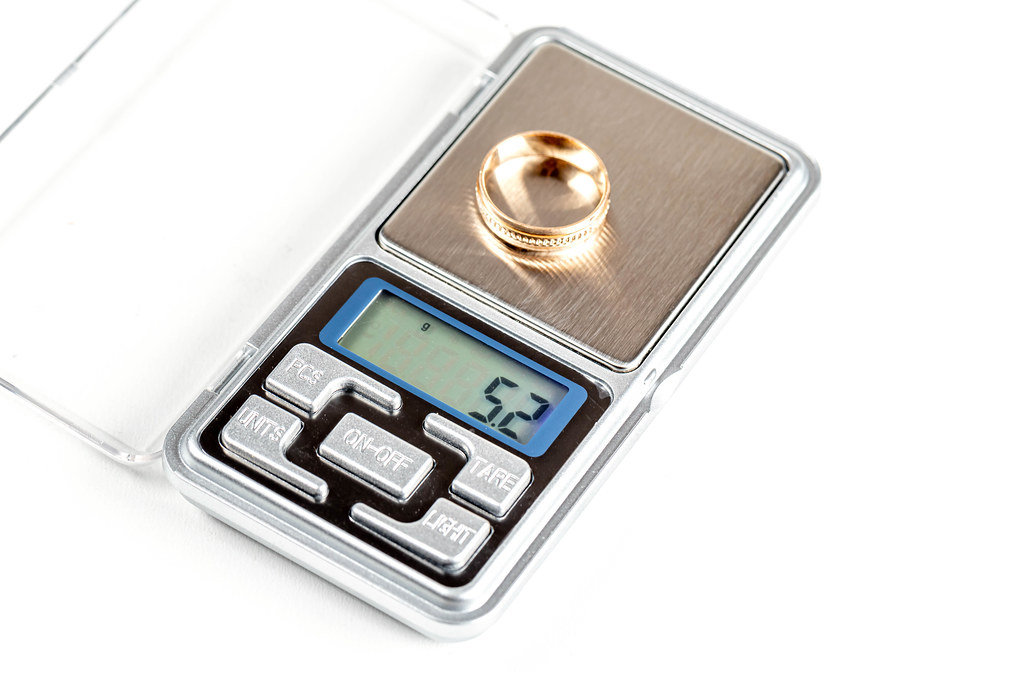 The gold ring is weighed on an electronic jewelry scale