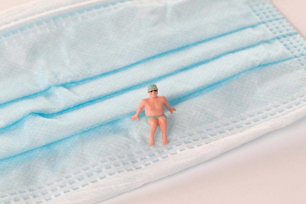 Man in bath suit relaxing on medical face mask