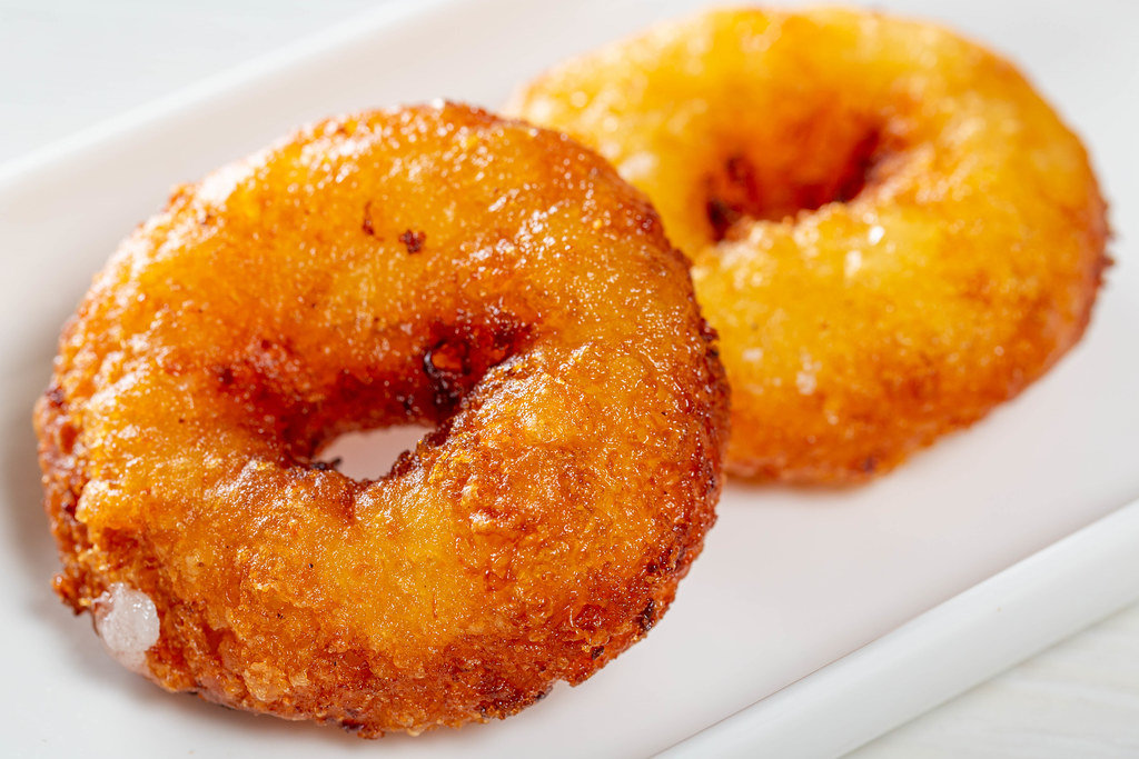Two homemade fried donuts on a white plate