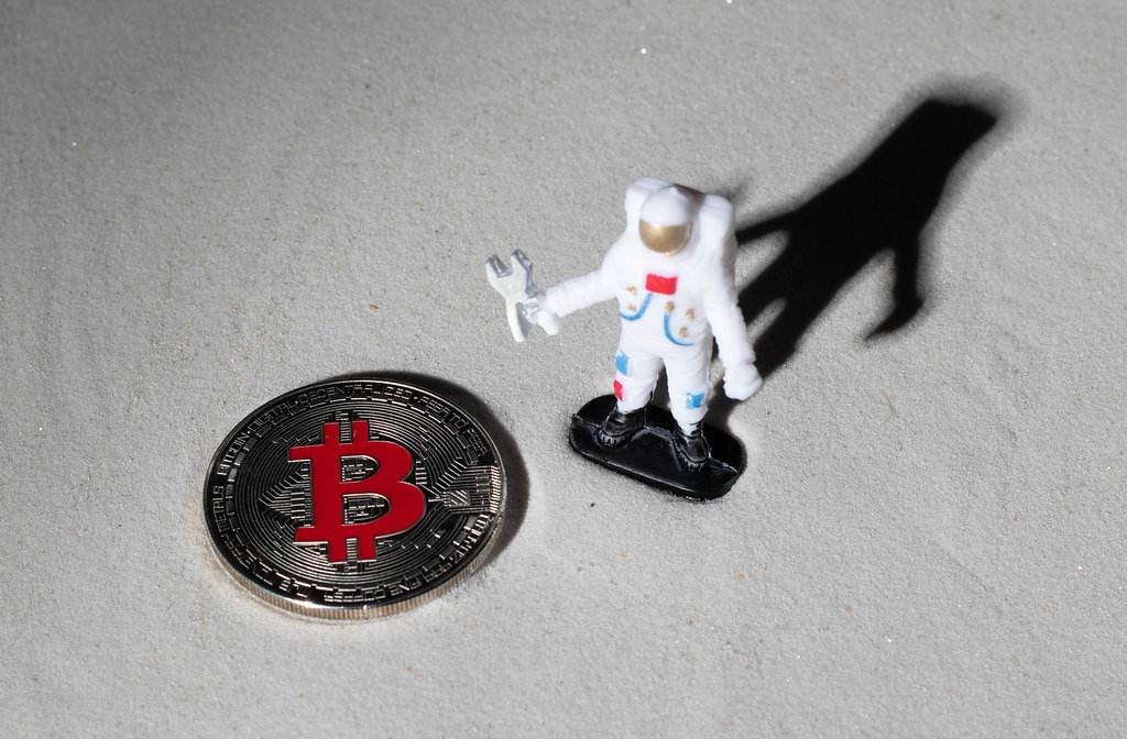 Astronaut and silver Bitcoin on the moon