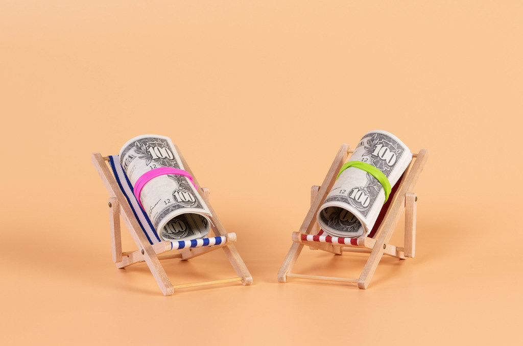 Rolls of dollar banknotes lying in a deck chair