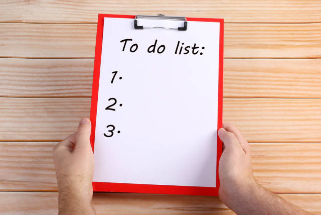 Hands holding clipboard with To do list