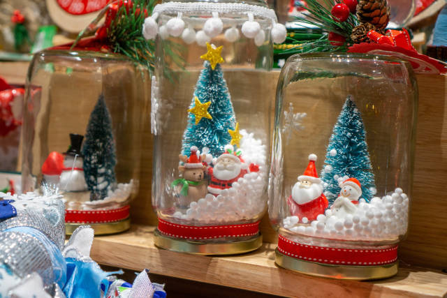 Close Up Photo of DIY Christmas Snow Globe Decorations in a Glass Jar with Miniature Snowman, Santa Claus and Christmas Tree