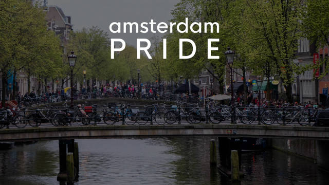 Tourists and bicycles on dutch bridges in the red light district of Amsterdam, with the title Amsterdam Pride