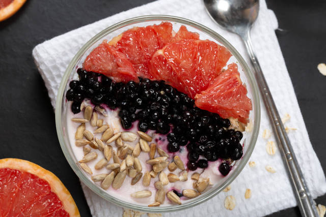 Breakfast oatmeal with yogurt, grapefruit, black elderberry and sunflower seeds