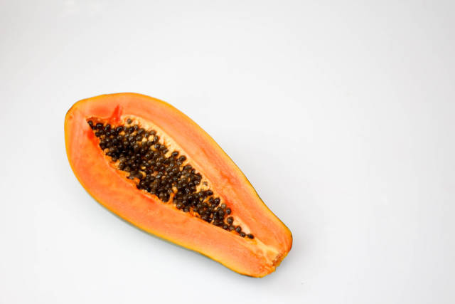 Halbierte Papaya vor weißem Hintergrund