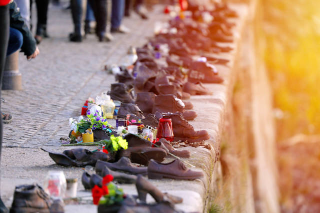 Flowers at Jews memorial in Budapest, shoes on Danube bank