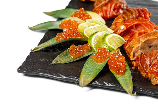 Close-up, smoked salmon fillet with red caviar and lime