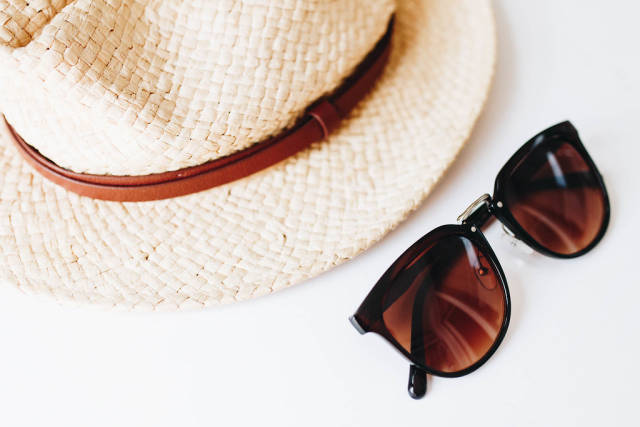 Beach hat and sunglasses. Beach accessories flat lay.