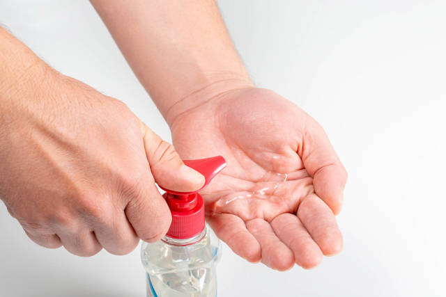 Male hands squeeze an antiseptic into his hands, close-up