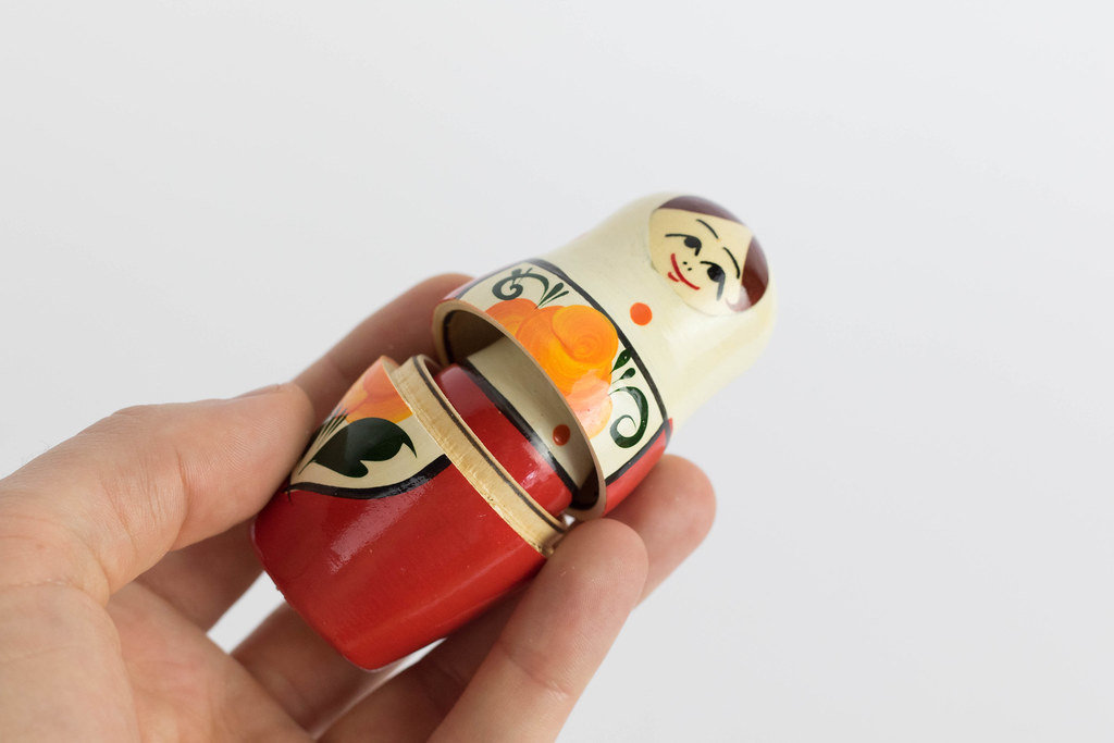 Winzige russische Puppe in einer Männerhand