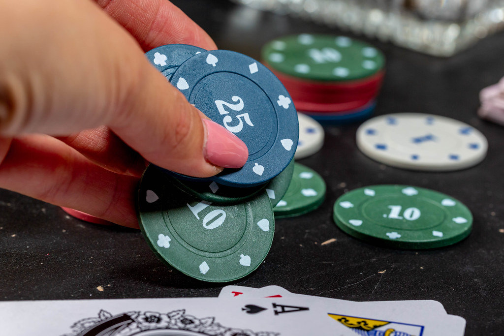 Womans hand puts on the table chips. The concept of rate increase