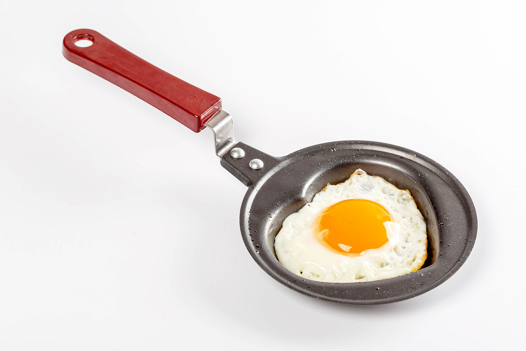 Small frying pan with fried egg in the shape of a heart