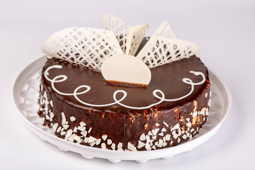 Whole brown chocolate cake with white chocolate decor
