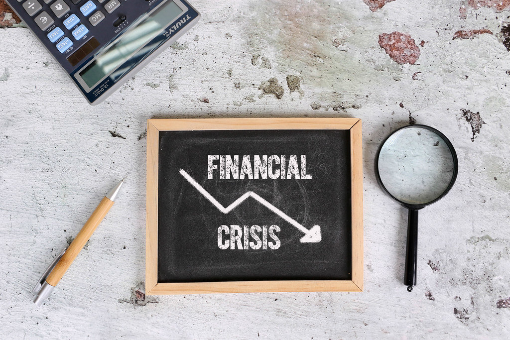 Text Financial Crisis written on a mini blackboard. Economic crisis concept