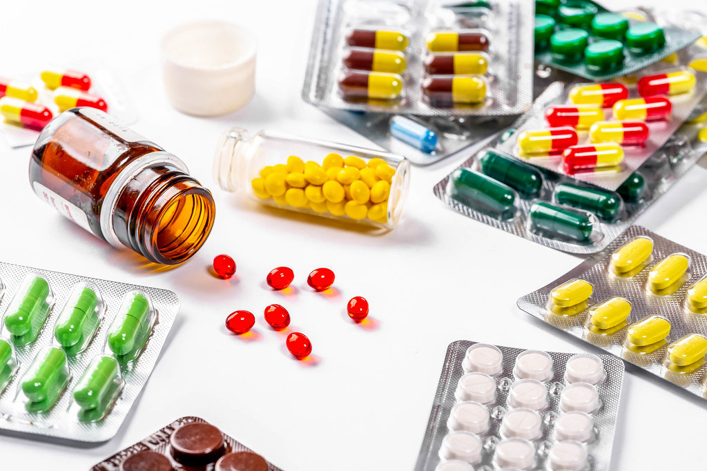 Viele verschiedene Tabletten und Pillen in allen Farben und Formen, auf weißem Untergrund