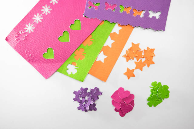 Different color paper cut outs on a white background