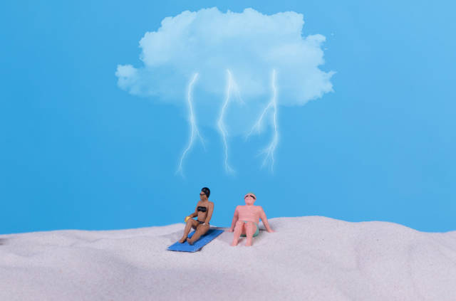 Couple in bath suit on the beach with storm cloud