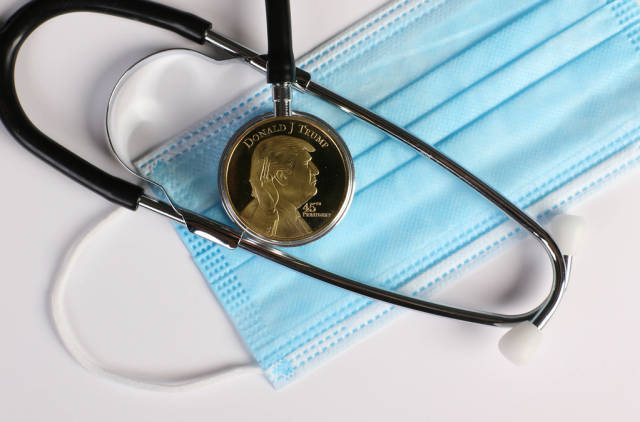 Golden Donald Trump coin with stethoscope and face mask