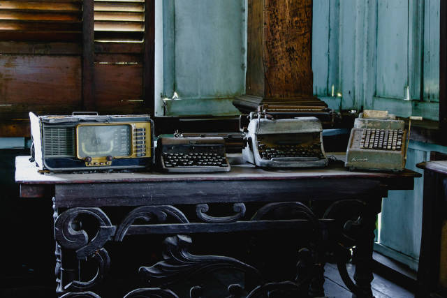 Vintage typewriters and radio on top of steel table