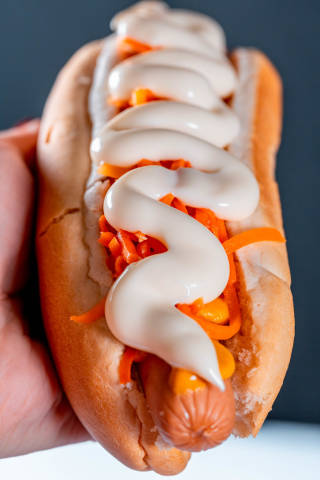 Hot dog with carrots and sauce