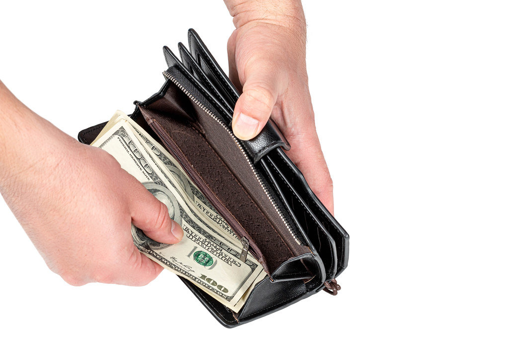 Mens hands put money in the wallet
