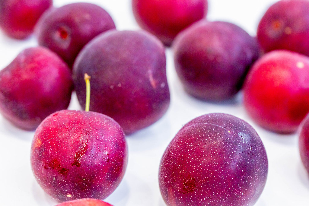 Fresh ripe plums on white background