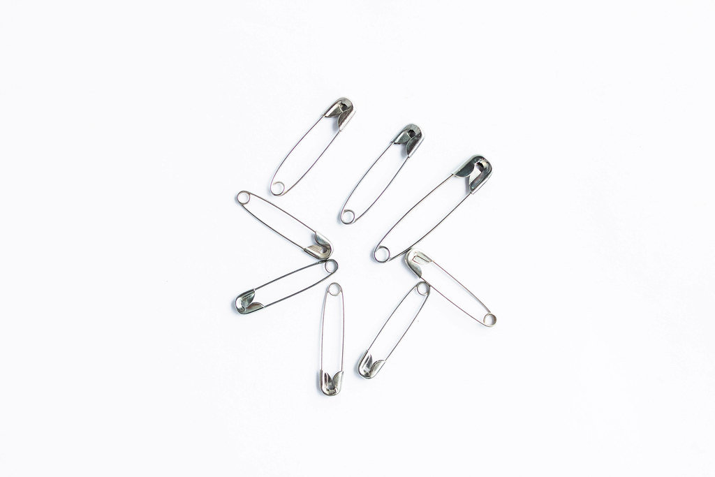 Safety pins isolated on white background Top View