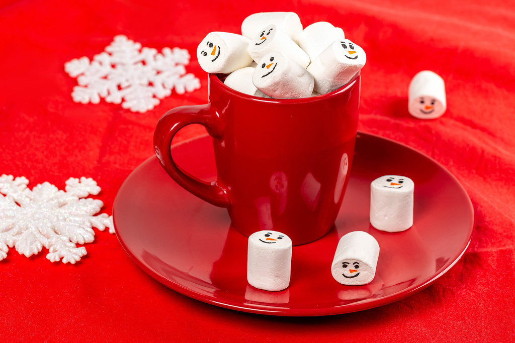 Red mug with marshmallows on a red background