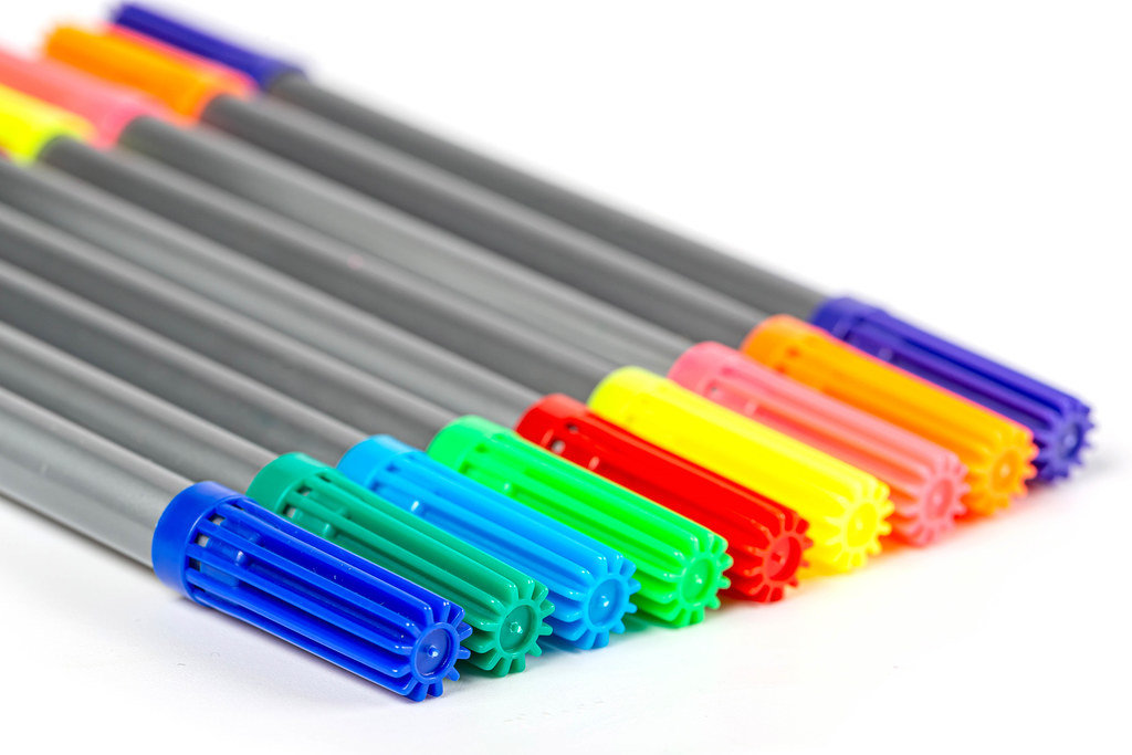 Multi-colored felt-tip pens on a white background, close-up