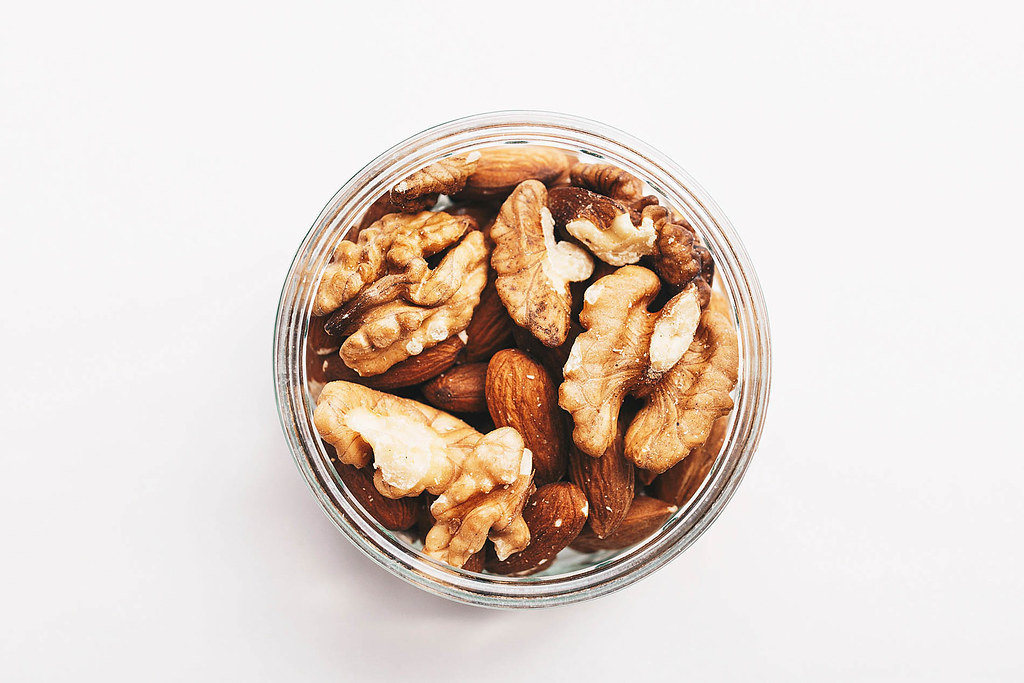 Top view of walnuts and almonds on white background.