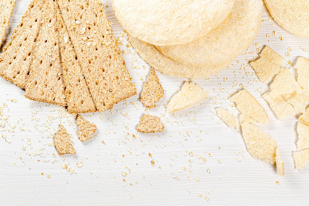 Set of crispy breads with sesame seeds and oatmeal on white background. Top view