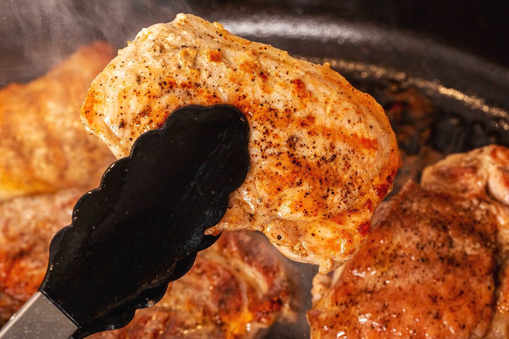 Close-up, fresh hot steak in kitchen tongs