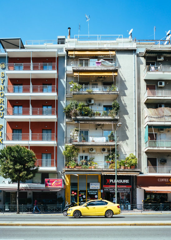 Typical Greece apartment building with taxi in front