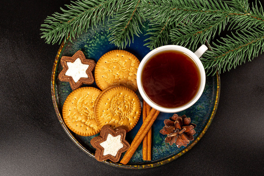 Top view, stars and round cookies with a cup of coffee and branches of a christmas tree