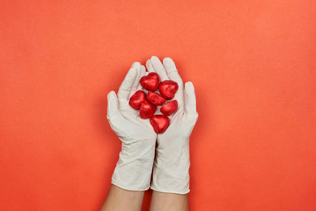 A female doctor in medical gloves holds in hands sweet chocolates