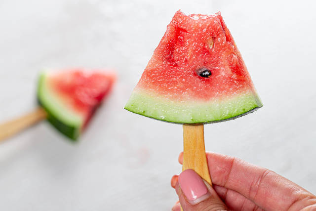 A half-eaten slice of ripe watermelon on a stick (Flip 2019)