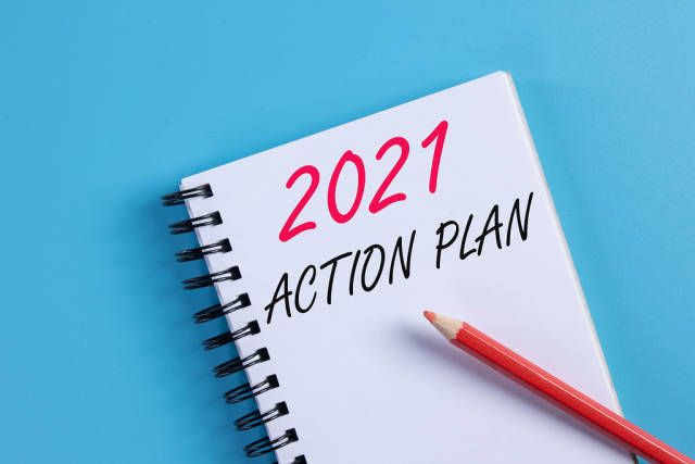 Notebook with 2021 Action Plan text on blue background
