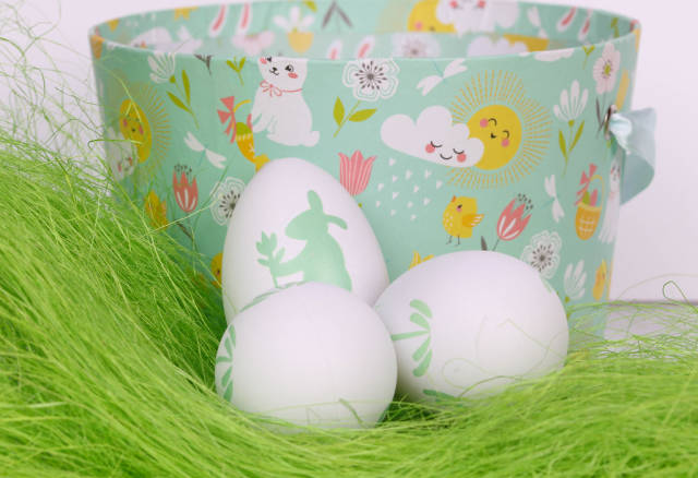 Easter eggs on green grass with basket