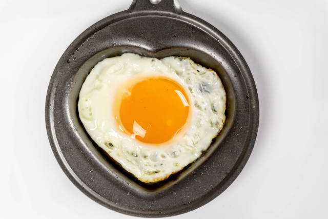 Traditional breakfast meal of fried egg on a frying pan, top view