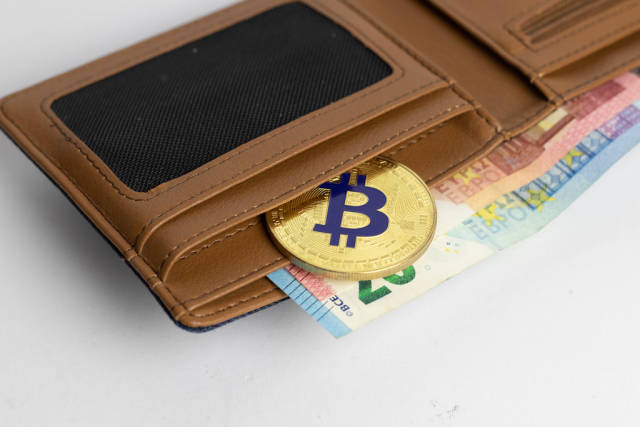 Golden bitcoin coin in the leather wallet