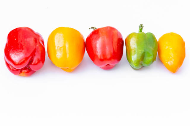 Bell peppers yellow, green and red on white background