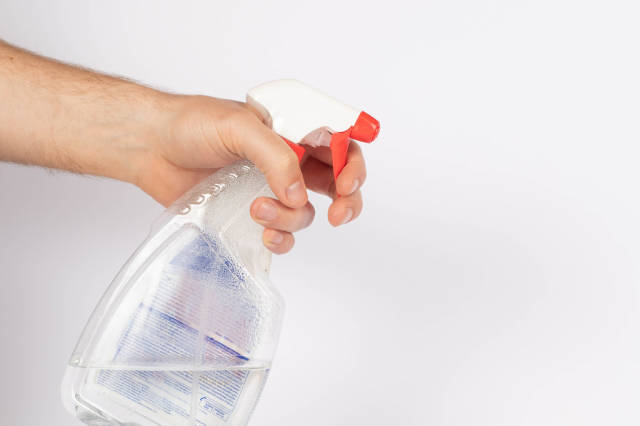 Hand with a cleaning product