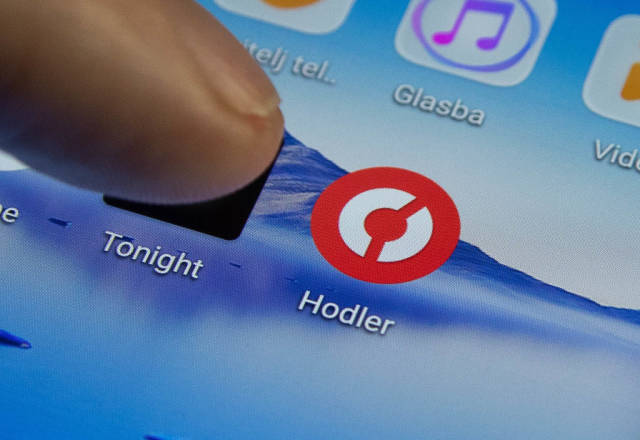 Finger pressing Hodler icon to load the app on a tablet or smartphone touchscreen
